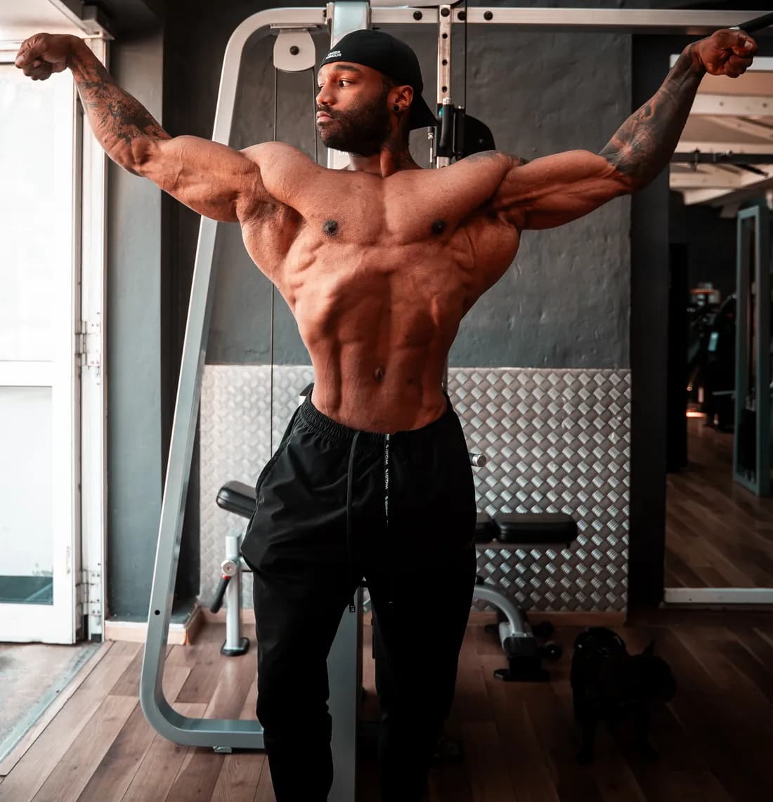 Dwayne beim Posing mit ausgebreiteten Armen im Fitnessstudio